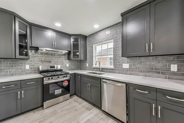 22 13th Ave N, Texas City, TX 77590 - kitchen with appliances with stainless steel finishes, a sink, light countertops, decorative backsplash, and under cabinet range hood