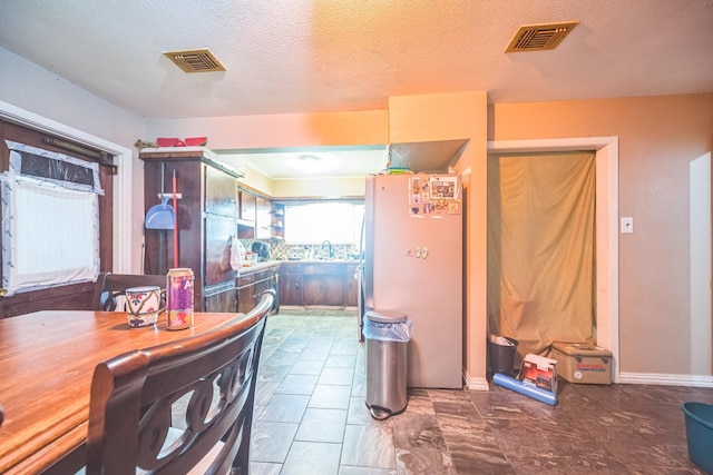 116 Chestnut St, Lake Jackson, TX 77566 - kitchen with visible vents, freestanding refrigerator, a sink, and baseboards