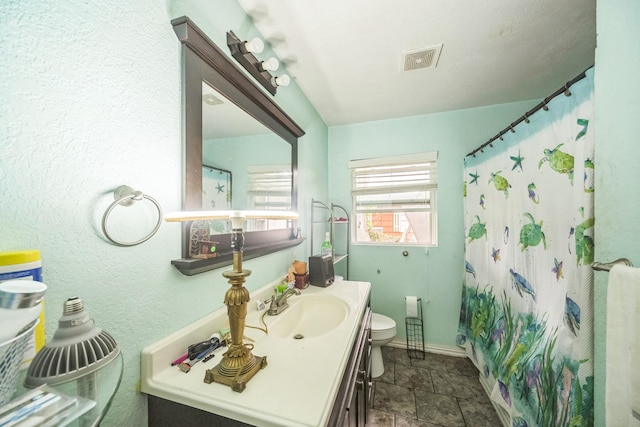 116 Chestnut St, Lake Jackson, TX 77566 - bathroom with vanity, toilet, baseboards, stone finish flooring, and visible vents