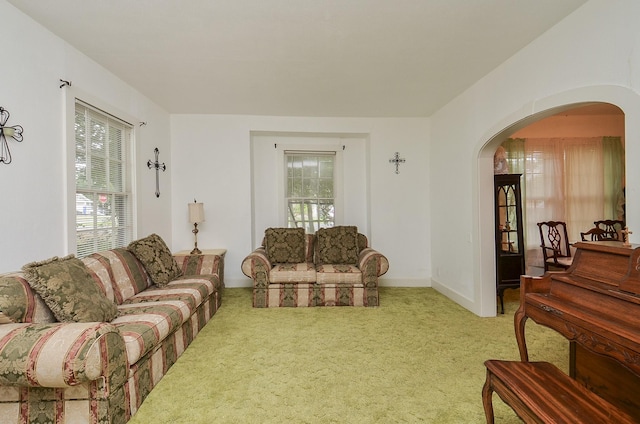 living room featuring arched walkways and carpet