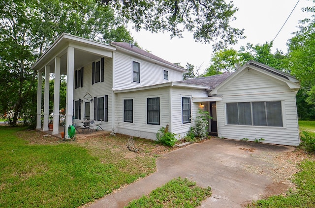 view of front of house featuring a patio and a front lawn