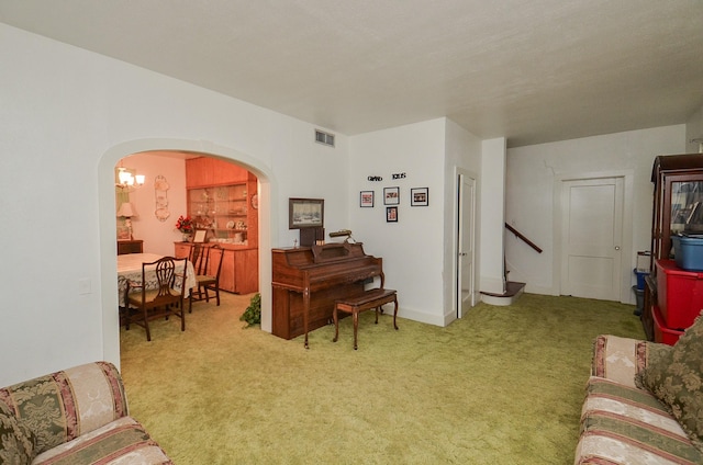 carpeted living room featuring stairway, arched walkways, and visible vents