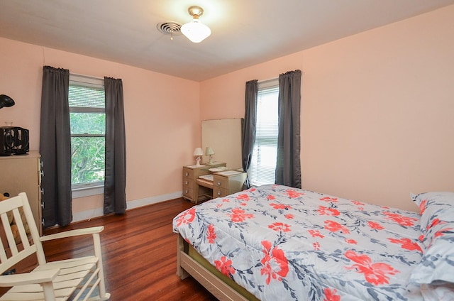 bedroom featuring baseboards, visible vents, and dark wood-type flooring
