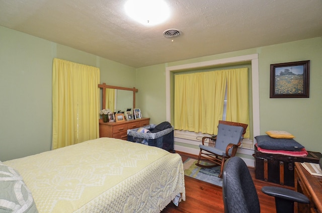 bedroom featuring visible vents and wood finished floors