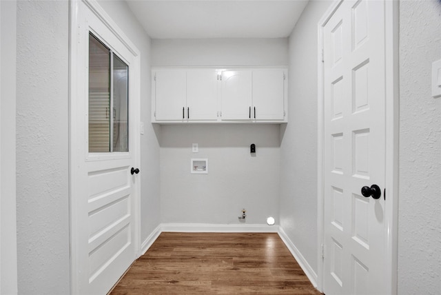 18330 Cape Bahamas Ln, Houston, TX 77058 - clothes washing area featuring dark wood-type flooring, hookup for a washing machine, cabinet space, and baseboards