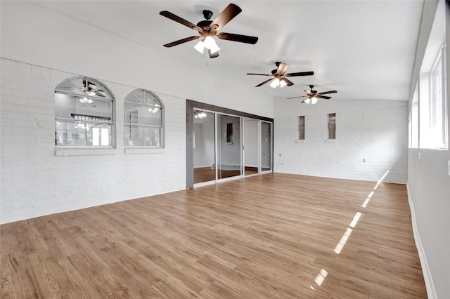 18330 Cape Bahamas Ln, Houston, TX 77058 - unfurnished living room featuring ceiling fan, vaulted ceiling, brick wall, and wood finished floors