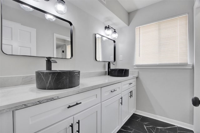 18330 Cape Bahamas Ln, Houston, TX 77058 - bathroom featuring double vanity, baseboards, a sink, and marble finish floor