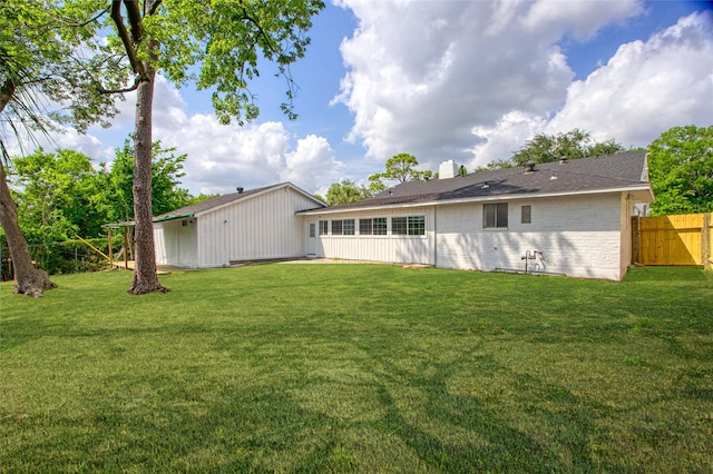 18330 Cape Bahamas Ln, Houston, TX 77058 - rear view of house featuring fence, a chimney, a lawn, and brick siding