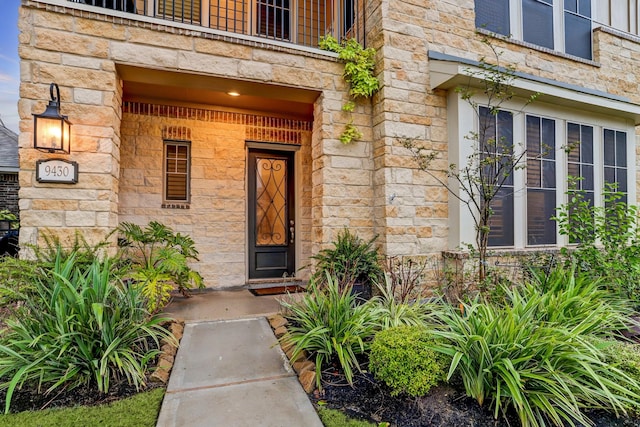 entrance to property featuring a porch and stone siding