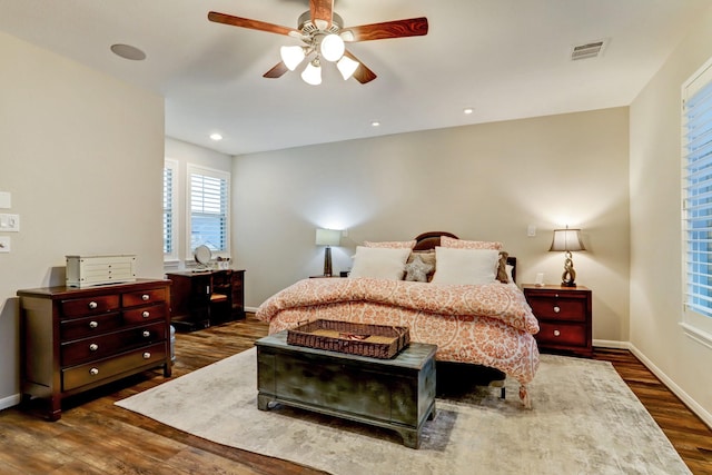 bedroom featuring baseboards, visible vents, a ceiling fan, and dark wood-type flooring