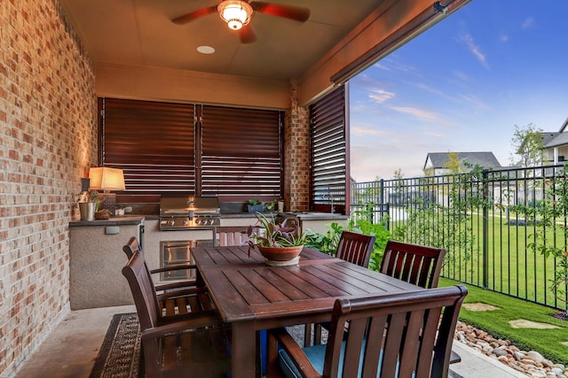 exterior space featuring a ceiling fan, outdoor dining area, exterior kitchen, fence, and a grill