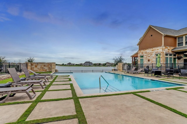 community pool with fence and a patio area