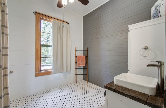 14203 Cypress Creek Blvd, Cypress, TX 77429 - full bathroom with ceiling fan, wooden walls, a shower with curtain, tile patterned floors, and vanity