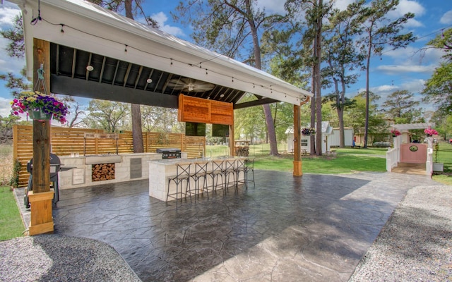 14203 Cypress Creek Blvd, Cypress, TX 77429 - view of patio with an outbuilding, fence, area for grilling, and exterior kitchen
