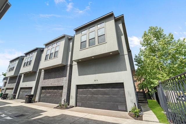 2616 Riverside Dr Unit A, Houston, TX 77004 - view of front of house featuring stucco siding, an attached garage, and fence