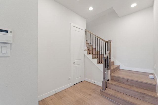 staircase featuring baseboards, recessed lighting, and wood finished floors