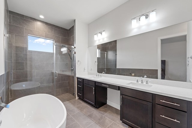 bathroom with a sink, a soaking tub, a shower stall, and double vanity