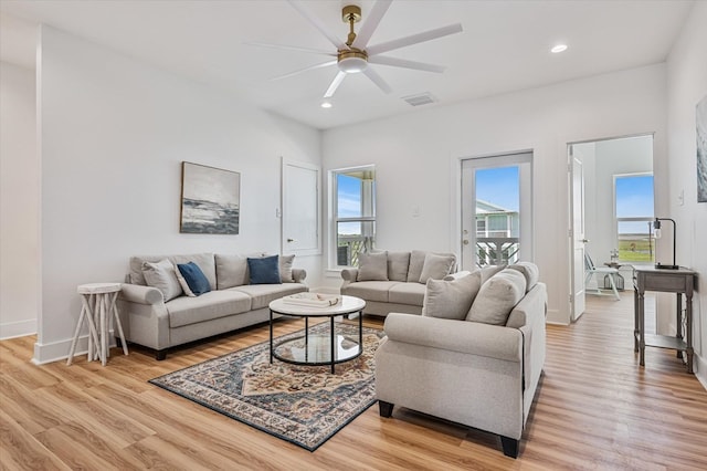 living room with light wood-type flooring, a ceiling fan, baseboards, and recessed lighting