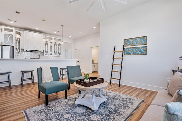 living area featuring a ceiling fan, visible vents, baseboards, recessed lighting, and light wood-style flooring