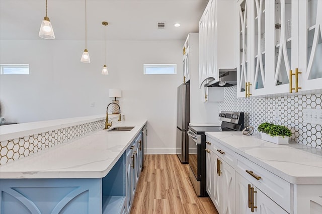 kitchen featuring a sink, decorative backsplash, white cabinets, and stainless steel appliances