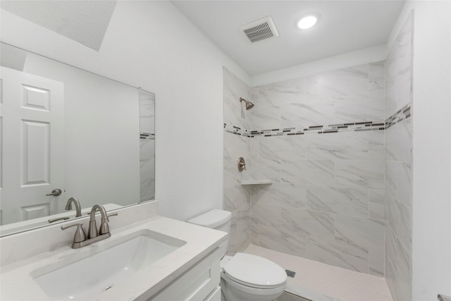 full bathroom featuring a tile shower, vanity, toilet, recessed lighting, and visible vents