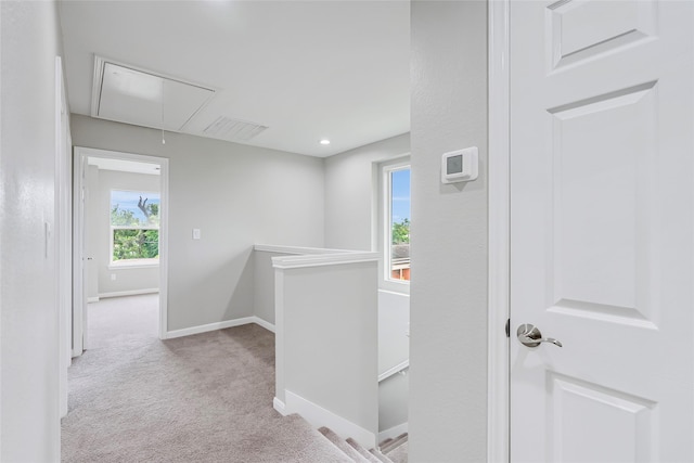 corridor featuring carpet flooring, attic access, baseboards, an upstairs landing, and visible vents