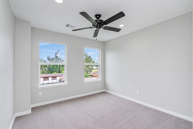 empty room with carpet flooring, recessed lighting, baseboards, and visible vents