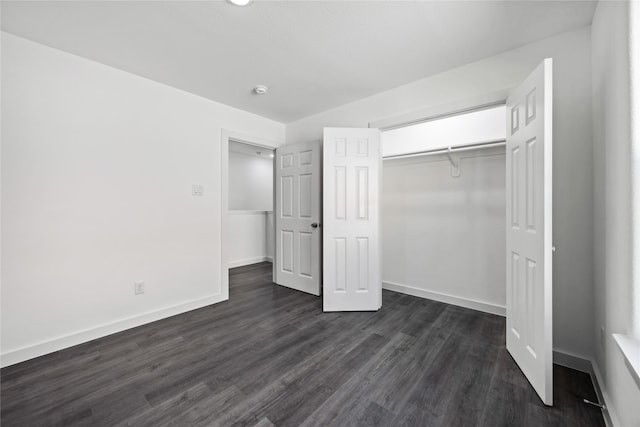unfurnished bedroom with baseboards, dark wood-style floors, and a closet