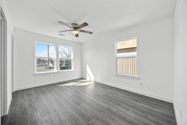 empty room featuring visible vents, dark wood-style flooring, ceiling fan, and baseboards