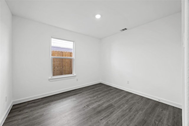 unfurnished room with recessed lighting, baseboards, visible vents, and dark wood-style floors