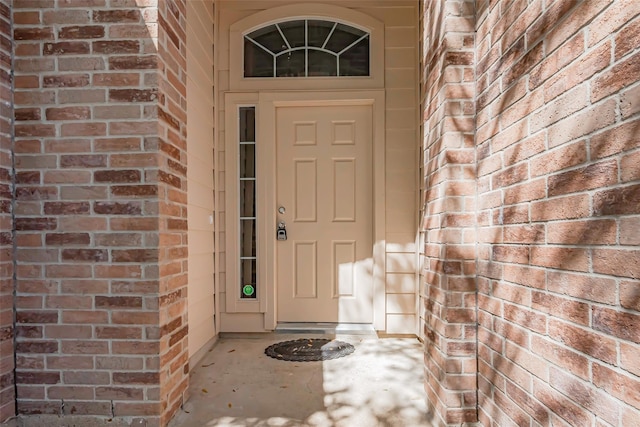 doorway to property featuring brick siding