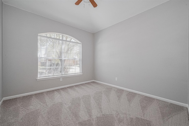 carpeted spare room with baseboards, a ceiling fan, and lofted ceiling
