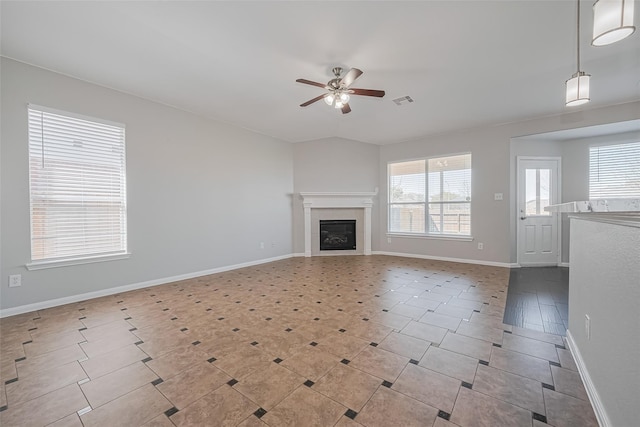 unfurnished living room with a glass covered fireplace, baseboards, ceiling fan, and visible vents