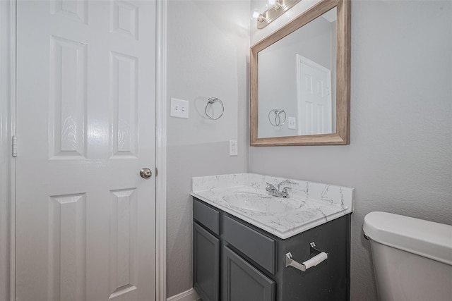 half bathroom with vanity and toilet