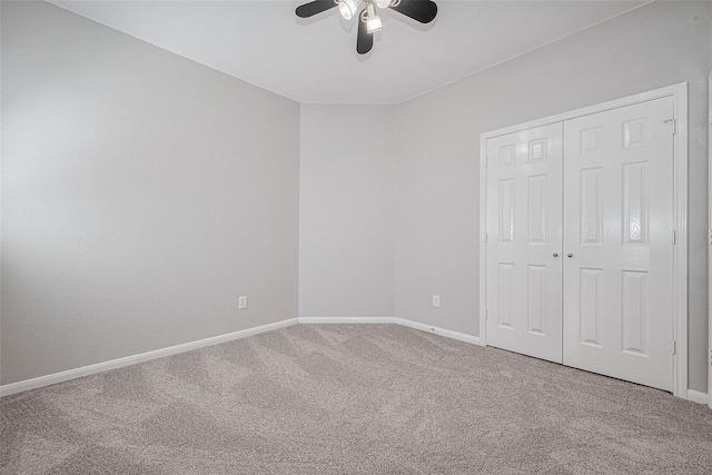 unfurnished bedroom featuring a closet, baseboards, a ceiling fan, and carpet flooring