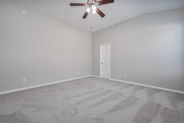 carpeted spare room with baseboards, a ceiling fan, and vaulted ceiling