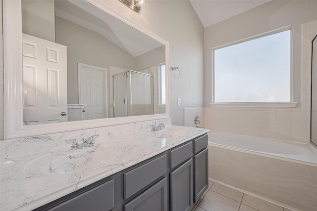 bathroom featuring a sink, double vanity, vaulted ceiling, a bath, and a stall shower