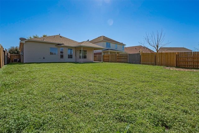 back of property featuring a lawn and a fenced backyard