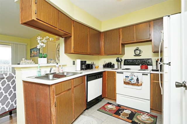 kitchen with light tile patterned flooring, a sink, white appliances, light countertops, and a peninsula