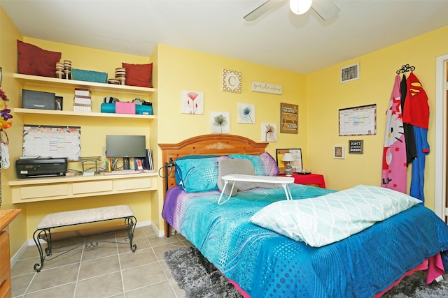 bedroom with ceiling fan, visible vents, tile patterned flooring, built in desk, and baseboards