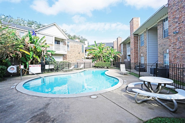 pool with fence and a patio area