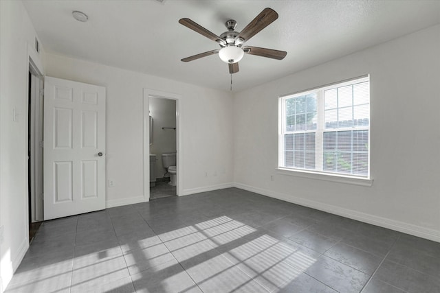 unfurnished bedroom with tile patterned floors, baseboards, ensuite bathroom, and visible vents