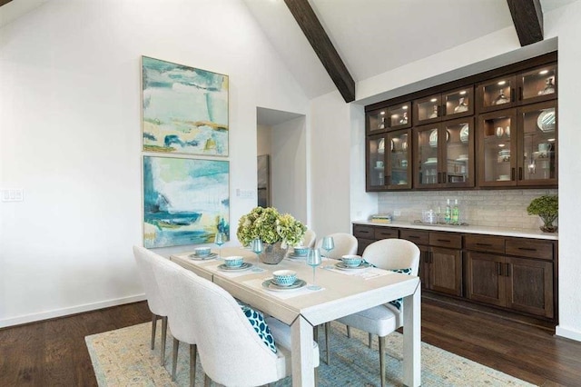 dining area featuring baseboards, lofted ceiling with beams, and dark wood-style flooring