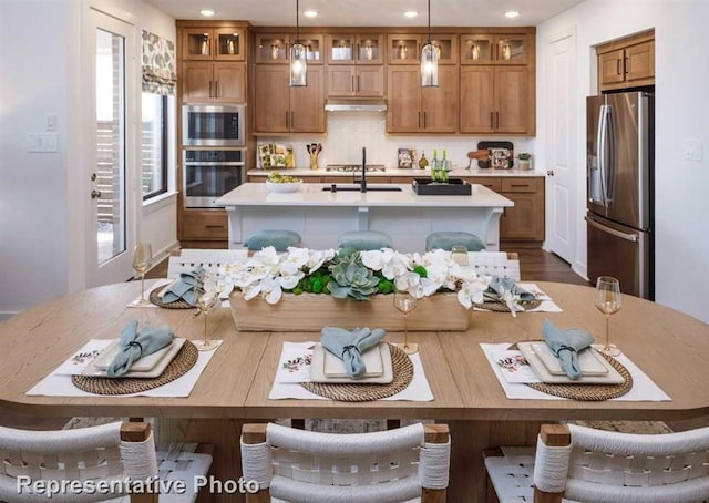 17708 Monarch Vista Ln, Conroe, TX 77302 - kitchen with stainless steel appliances, light countertops, brown cabinetry, and recessed lighting