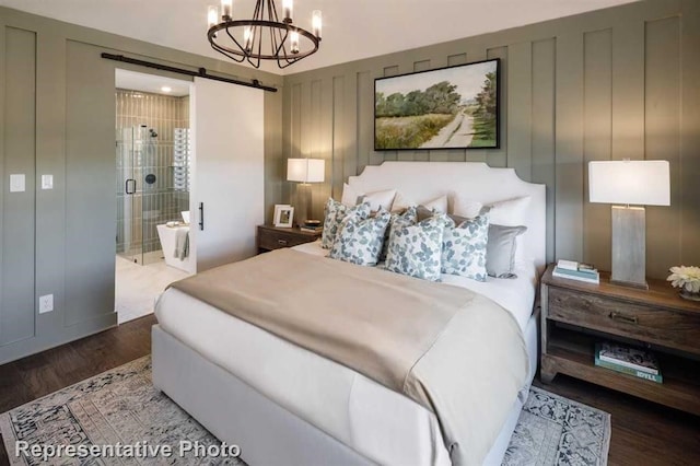 17708 Monarch Vista Ln, Conroe, TX 77302 - bedroom with a barn door, wood finished floors, a chandelier, and connected bathroom