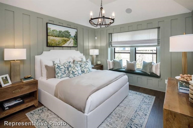 17708 Monarch Vista Ln, Conroe, TX 77302 - bedroom featuring a chandelier, a decorative wall, dark wood-style flooring, and lofted ceiling