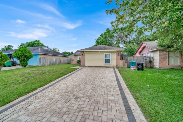 view of front of house featuring fence, decorative driveway, a front lawn, and brick siding