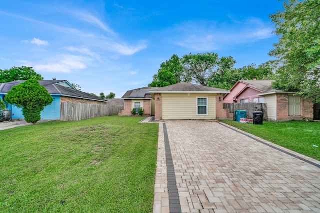 ranch-style home with fence, solar panels, a front lawn, and brick siding