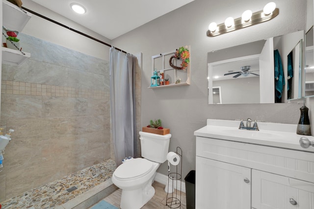 full bath featuring vanity, a ceiling fan, toilet, and tiled shower