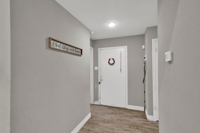 hall featuring light wood-style floors and baseboards